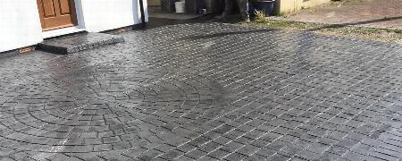 newly installed stamped concrete driveway featuring decorative patterns and a modern design